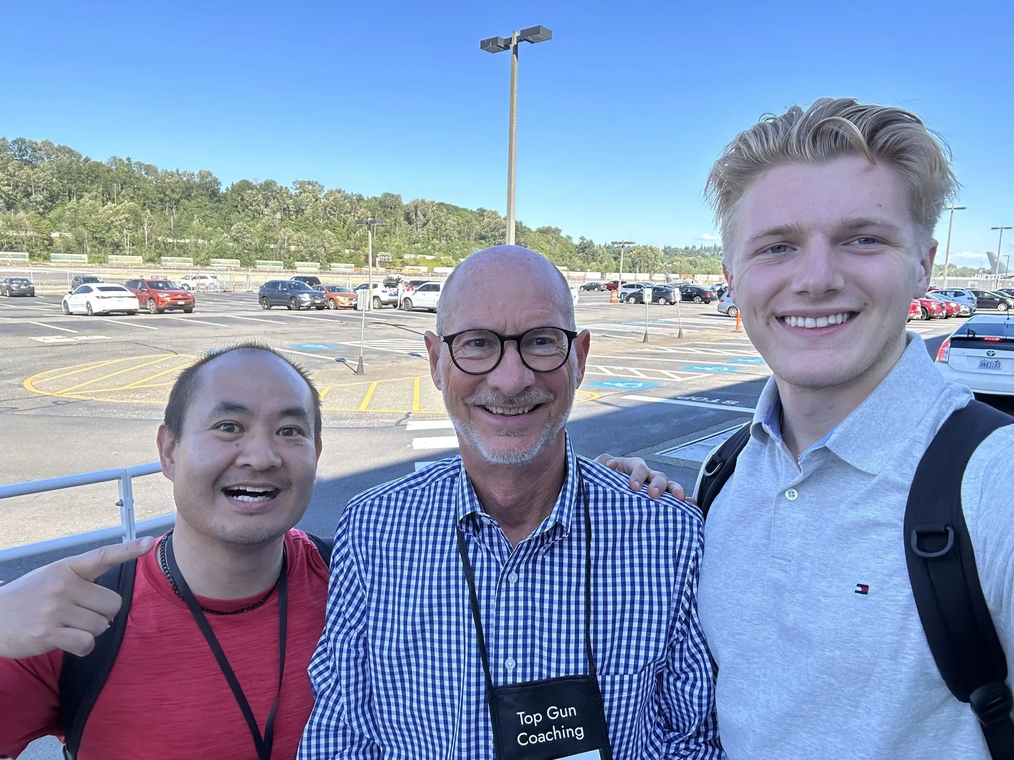 Dan Leibrandt taking a selfie with two men outside in a parking lot, one wearing a Top Gun Coaching lanyard